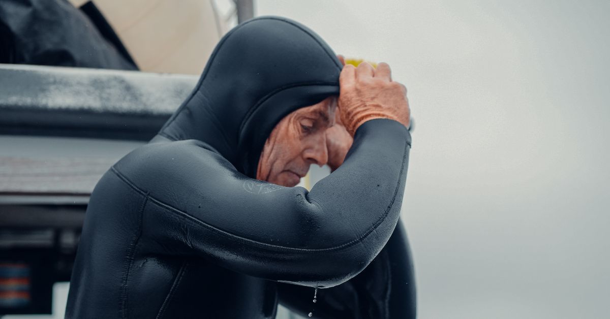 Man putting on a wetsuit hood