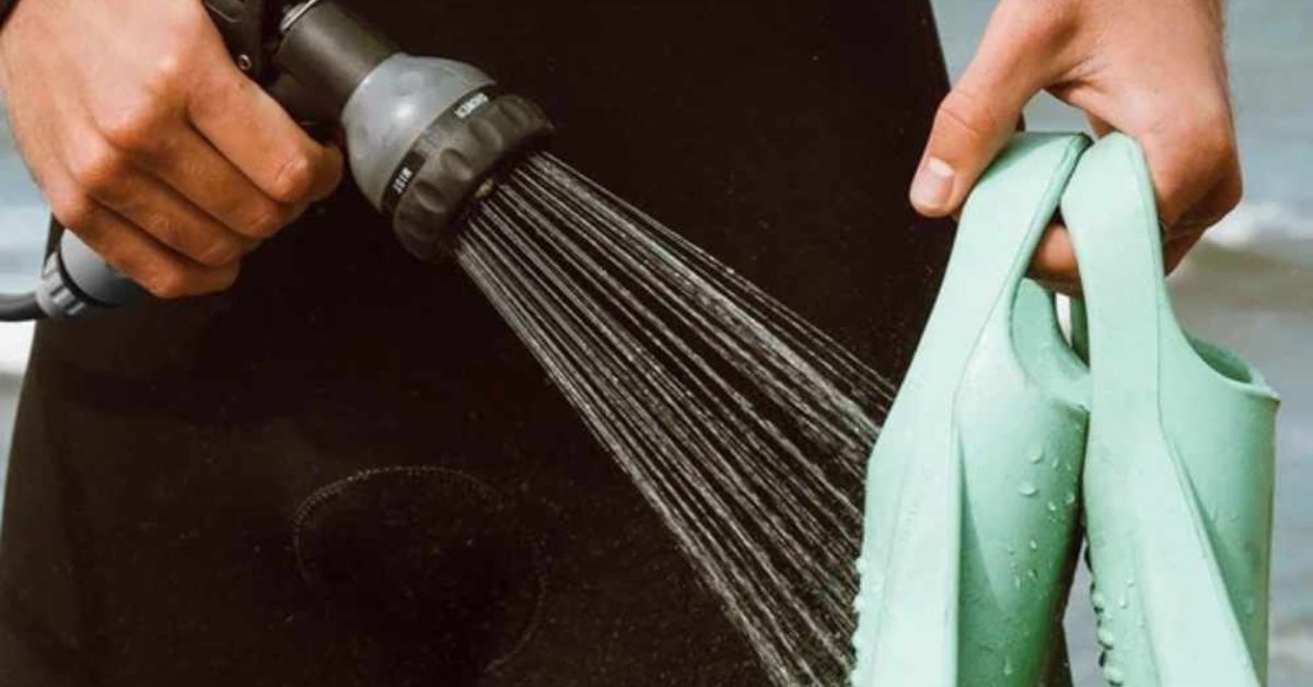 Person using a hose to spray down some flippers